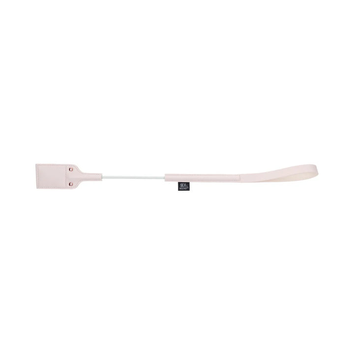 Pale peach riding crop with a looped faux leather tip cut out in the shape of a peach
