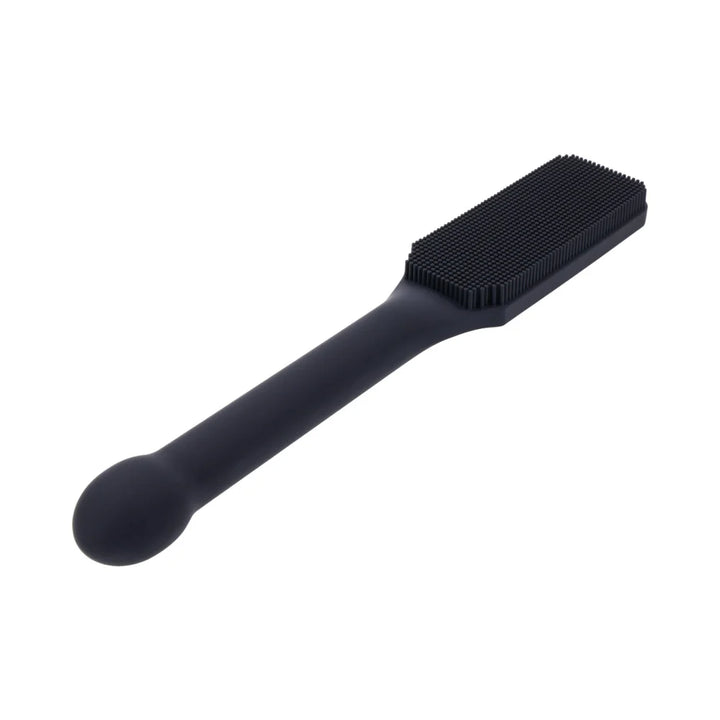 Black silicone paddle with a head covered in fine needle-like bristles and a long handle