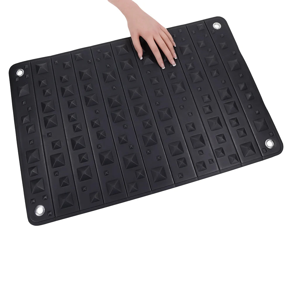 Black foam mat covered in pyramid spikes, shown rolled into its buckled faux leather holster