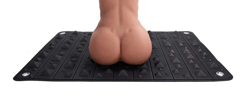 Black foam mat covered in pyramid spikes, shown rolled into its buckled faux leather holster