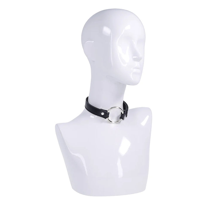 Black faux leather strap with a silver O-ring, worn as a bracelet, cross cuffs, or a day collar