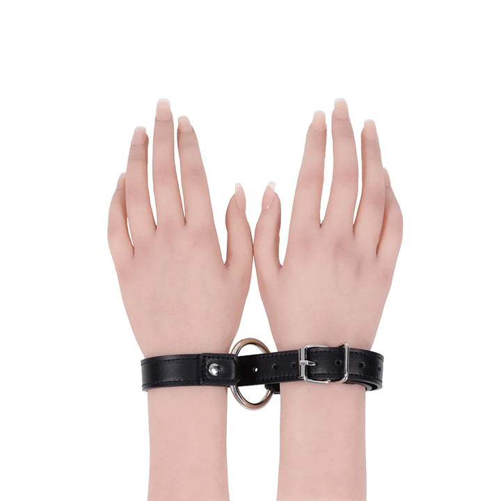 Black faux leather strap with a silver O-ring, worn as a bracelet, cross cuffs, or a day collar