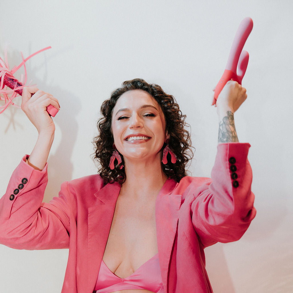 Woman in a pink outfit with a disco ball and pink shoes on a white background